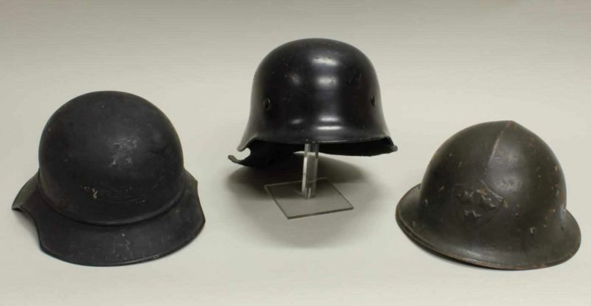 Konvolut von 3 Helmen: - Feuerwehrhelm mit Nackenschutz, Innenfutter; - Luftschutzhelm, 3. Reich,