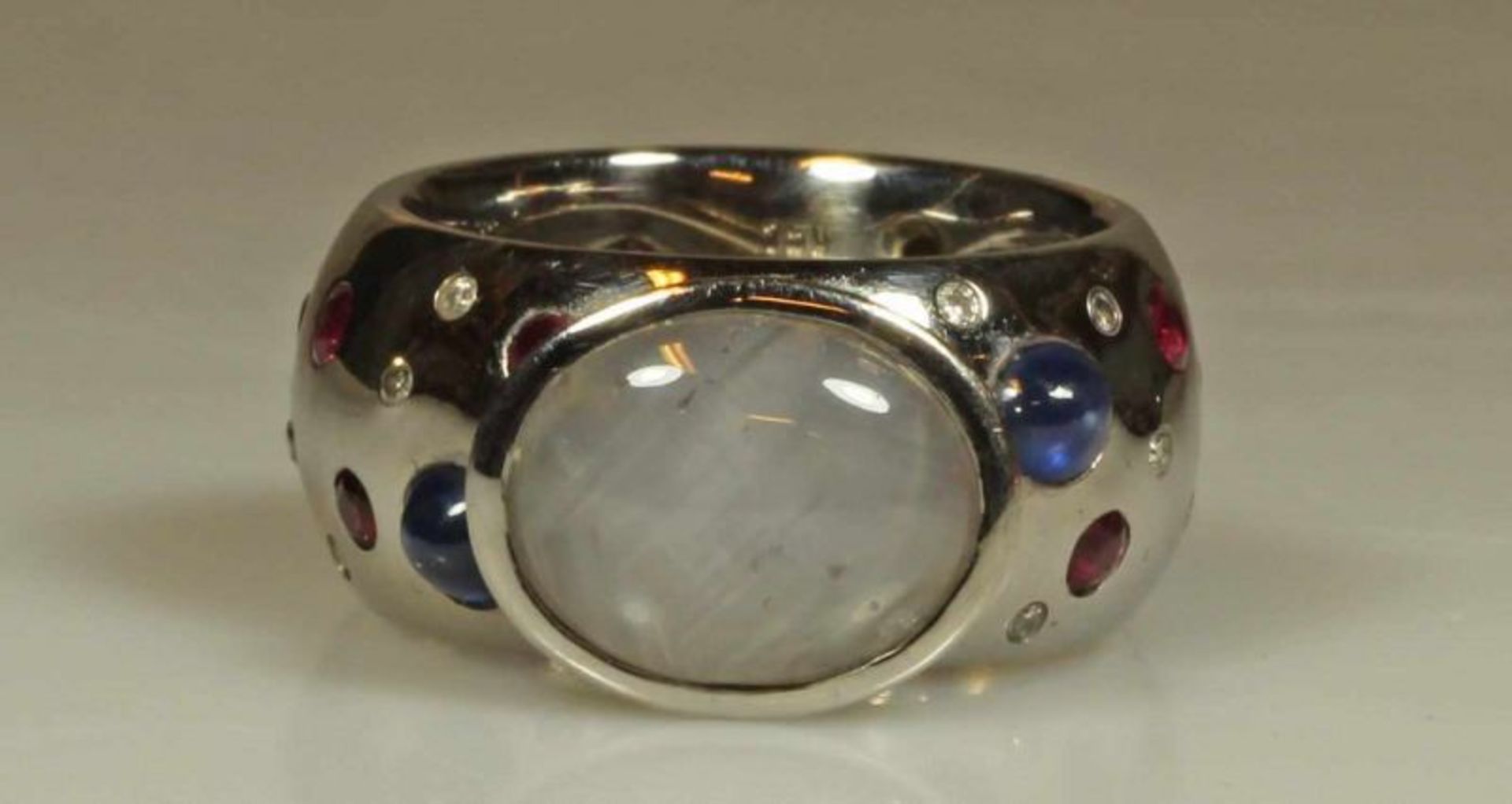 Ring, WG 750, großer Sternsaphir-Cabochon, Schiene besetzt mit 2 Saphir-Cabochons, je 16 Rubine