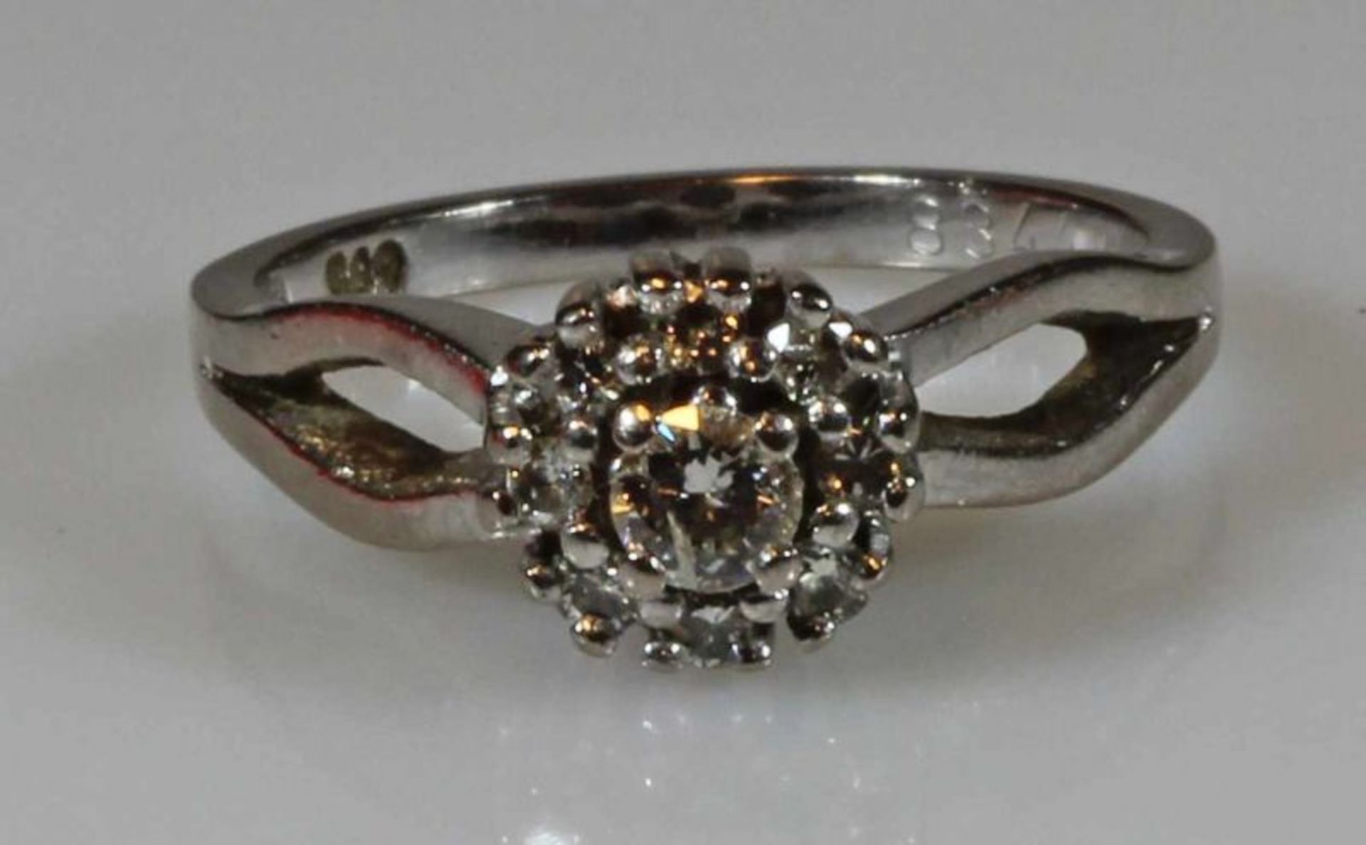 Ring, WG 585, 1 Brillant ca. 0.15 ct., 8 kleine Besatz-Brillanten, 5 g, RM 17.5 20.00 % buyer's