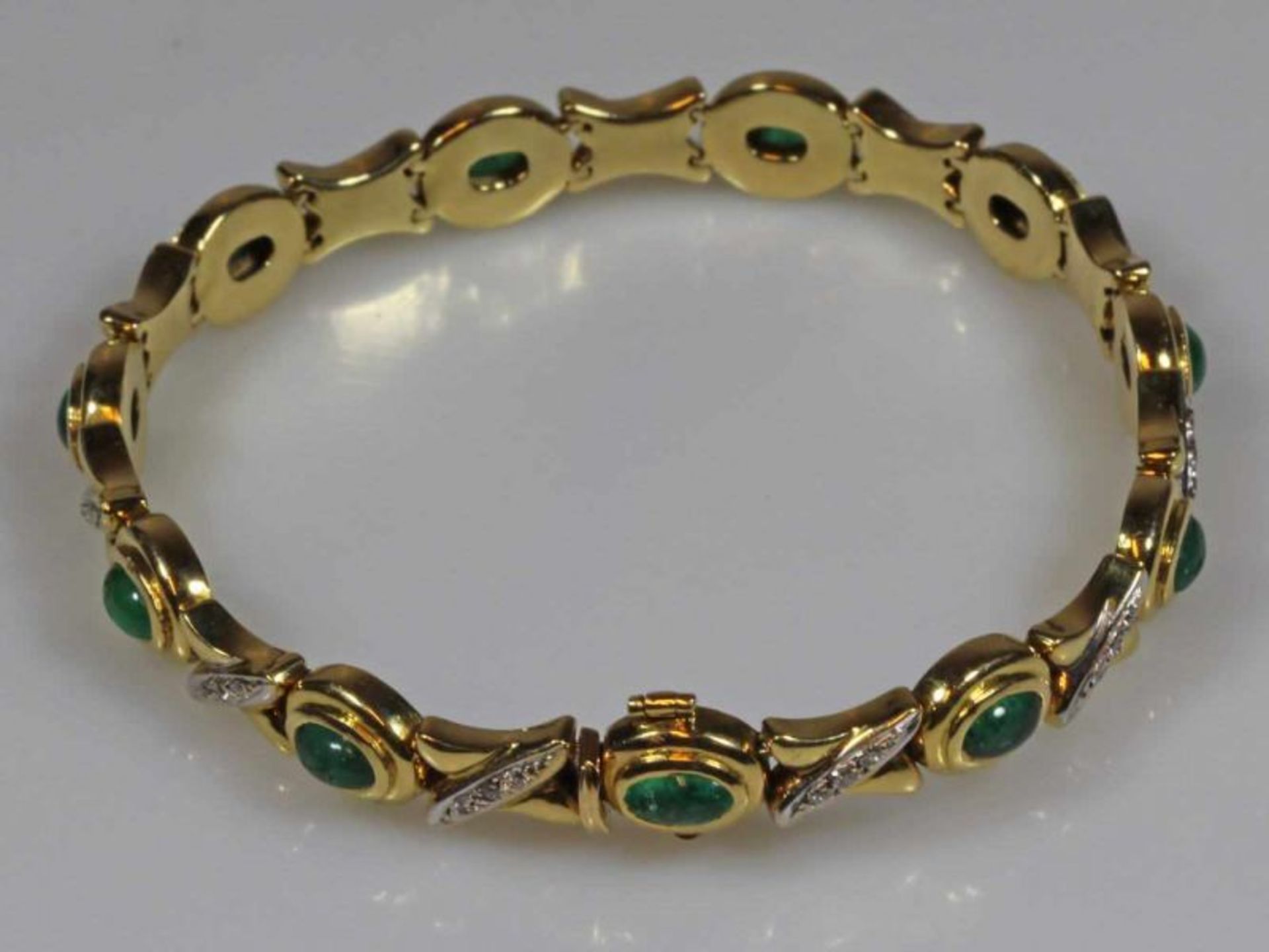 Armband, GG 750, 11 ovale Smaragd-Cabochons zus. ca. 4.50 ct., 33 Brillanten zus. ca. 0.30 ct., 19.5