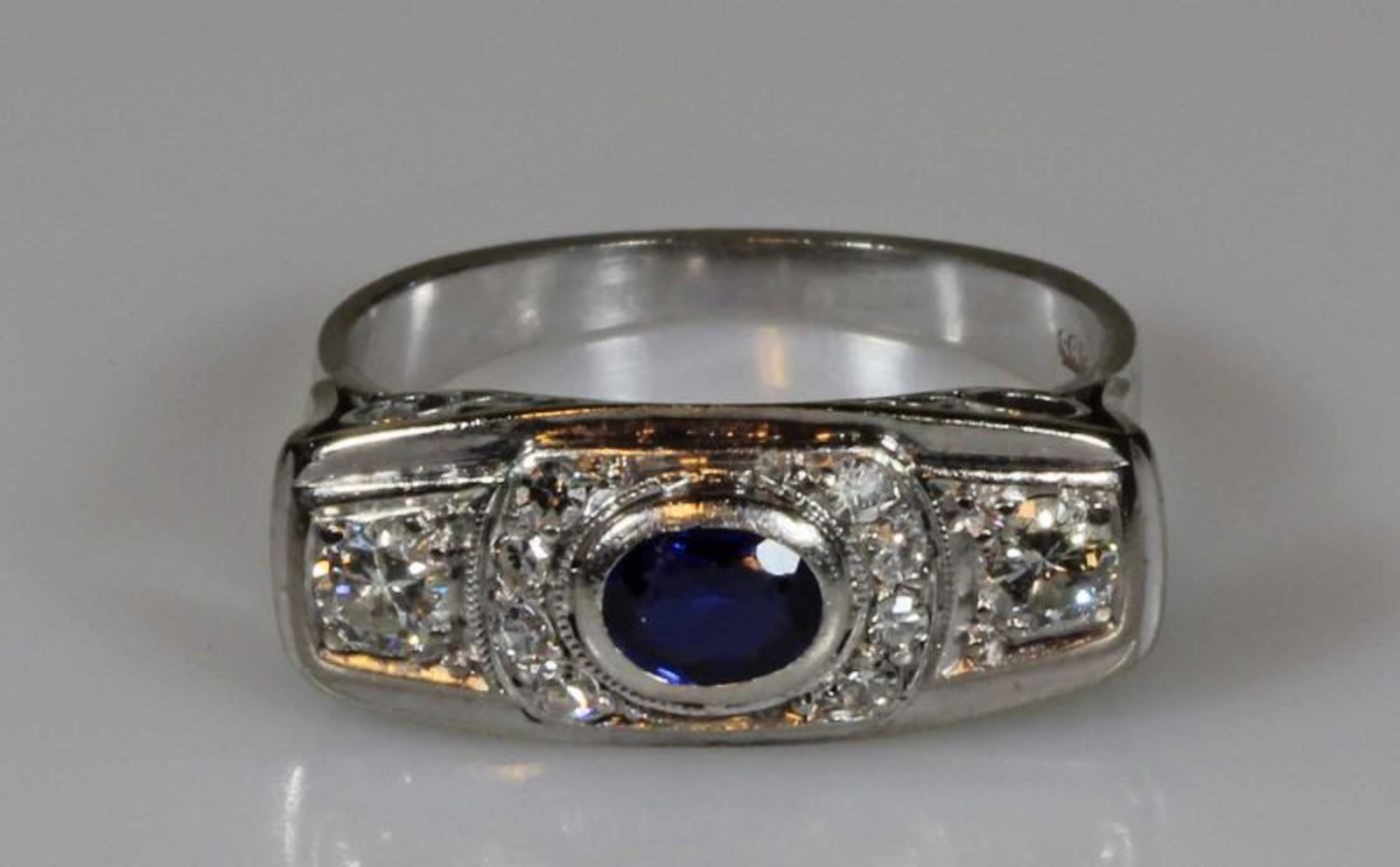 Ring, WG 585, 1 ovaler facettierter Saphir ca. 0.55 ct., 2 Brillanten zus. ca. 0.30 ct., etwa w/