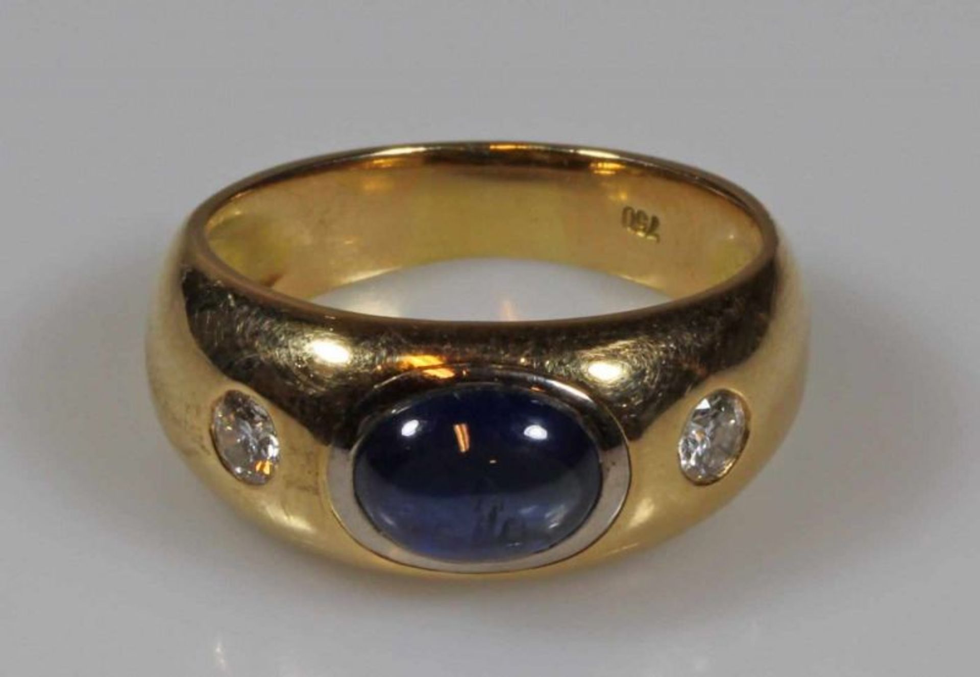 Bandring, GG 750, 1 Saphir-Cabochon, 2 kleine Brillanten zus. ca. 0.30 ct., 8 g, RM 18.5 20.00 %