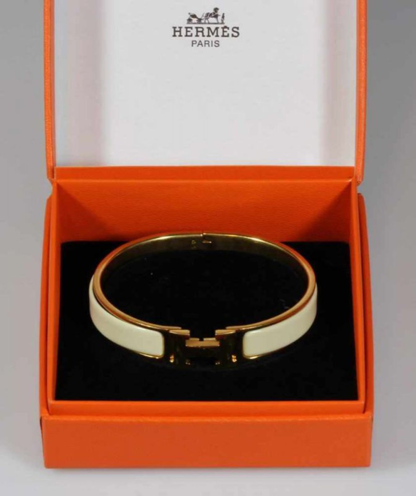 Armreif, Hermès, Modell "Clic H", Metall vergoldet, cremefarbenes Email, ø 6 cm, Breite 11 mm,