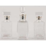 3 Karaffen Glas/925er Silber, England/Holland, 20.Jh. 3-tlg. Hochrechteckige Form m. Silberkragen.