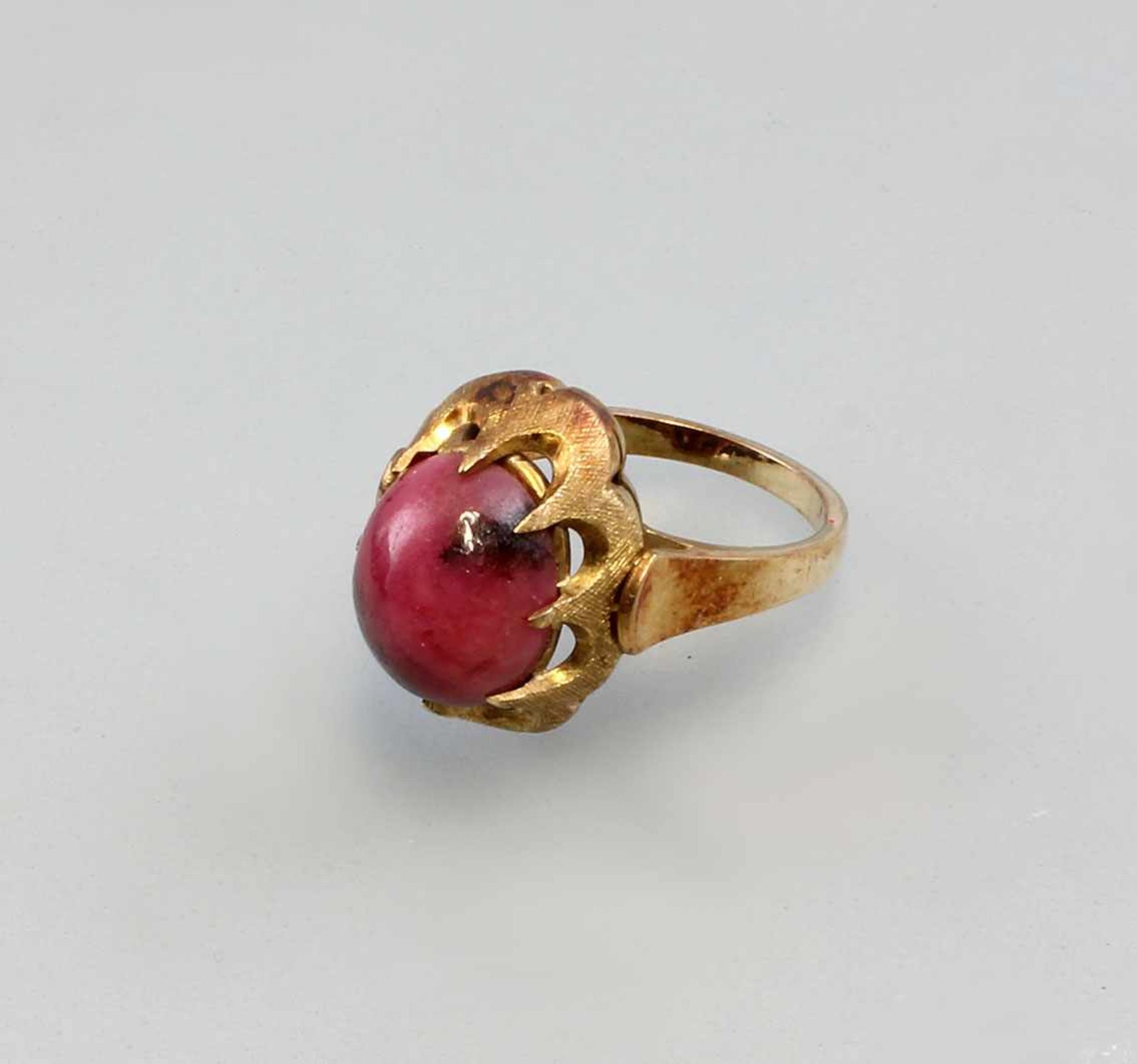 Ring mit roséfarbenem Cabochon . 585er GG, ges. 6,9 g, durchbrochen gearbeiteter Ringkopf mit