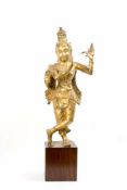 Krishna auf Holzsockel Südindien, um 1920, Bronze, mit Goldfarbe staffiert, Höhe 86 cm, Finger einer