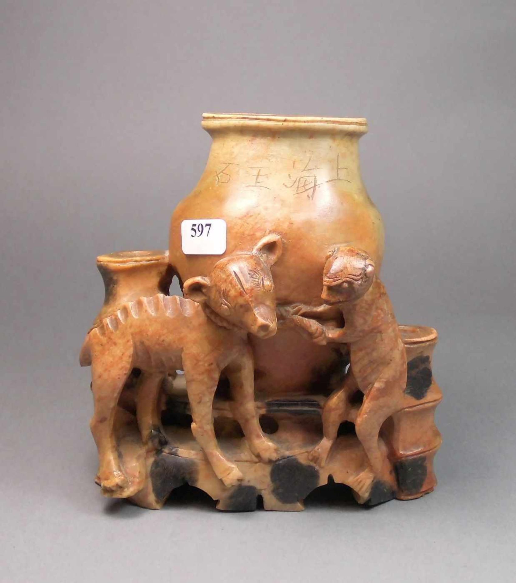 SKULPTUR: "Affe und Hund vor einer Vase", rötlicher Speckstein, schwarz akzentuiert; auf der Wandung