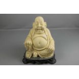 FIGUR: "Sitzender Buddha", elfenbein- und ebenholzfarbene Masse. Sitzender, lächelnder Buddha, in