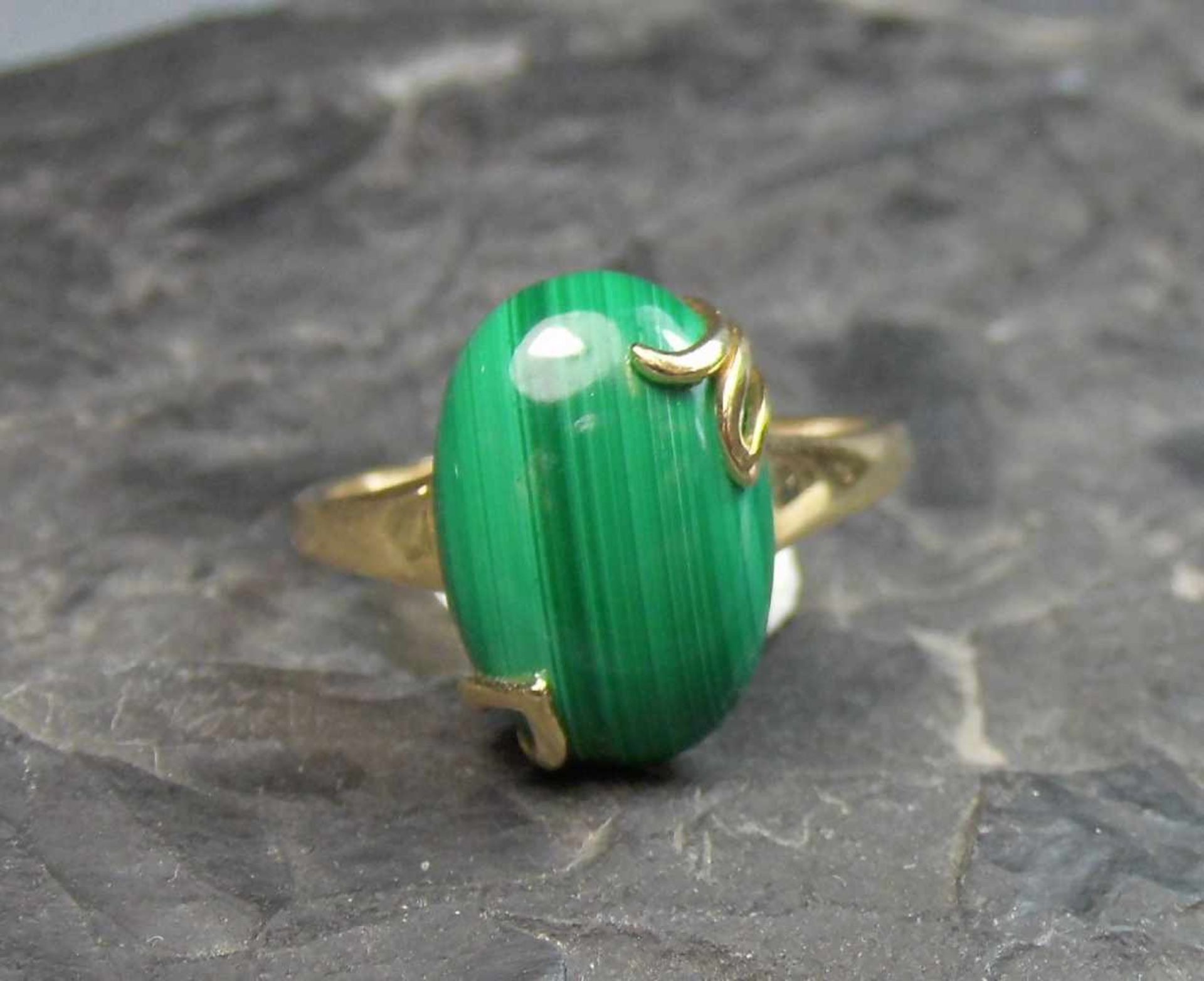 RING mit Malachit im Cabochon-Schliff in 585er Goldmontur (4,4 g); ungetragen. Ring-Gr. 56.