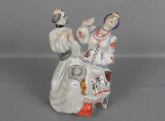 FIGURENGRUPPE: "Priester und Frau in Kosaken - Tracht", Porzellan, unter dem Stand gemarkt mit