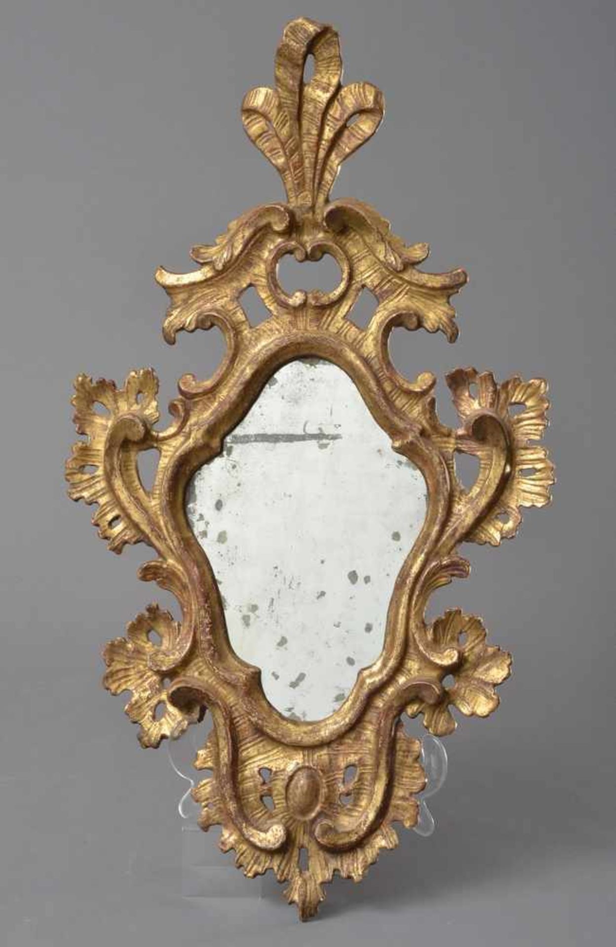 Barocker Spiegel mit altem Glas in einer geschweiften Raute, hohe Schleifenbekrönung mit