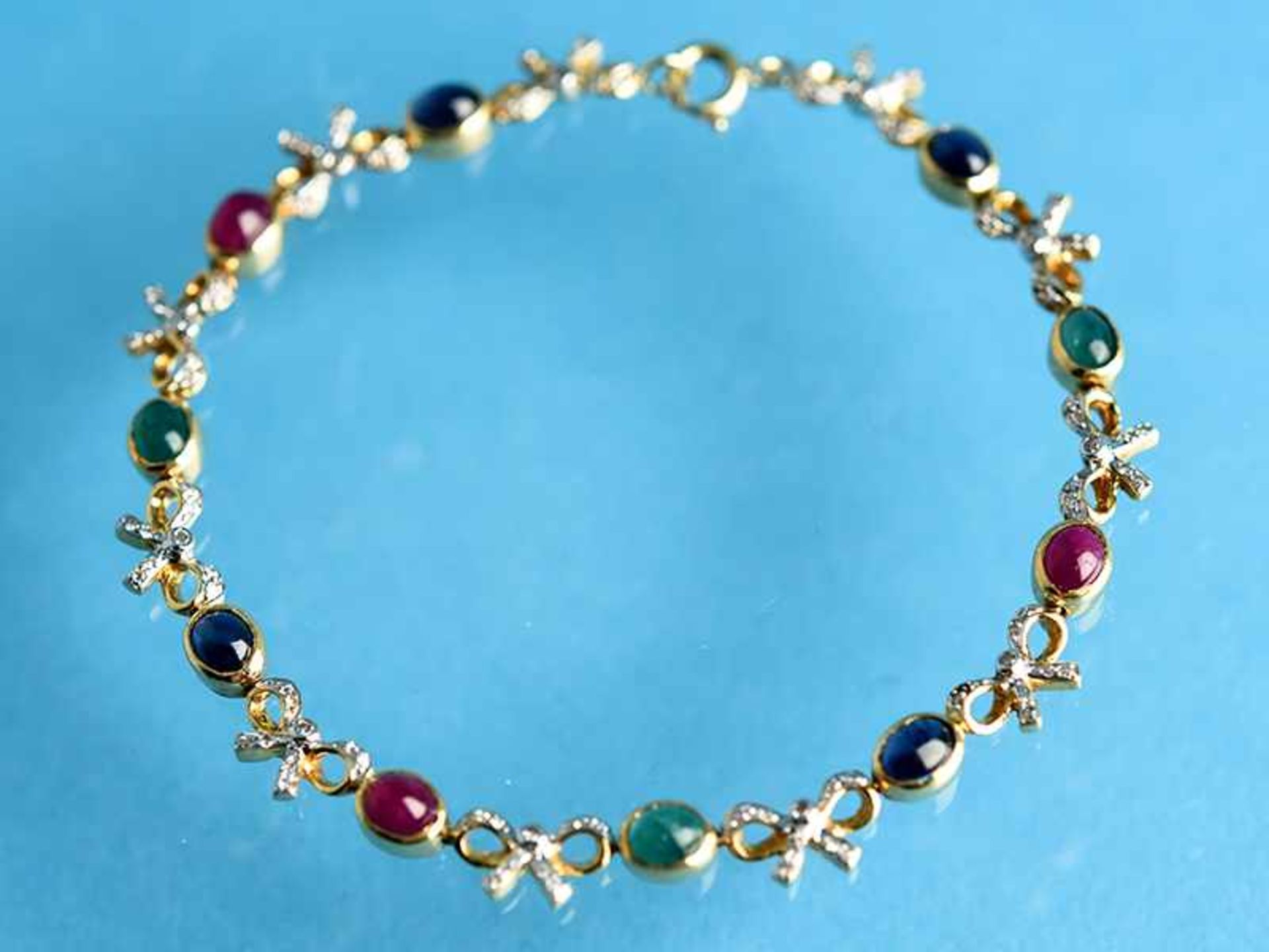 Armband mit Saphit-, Rubin-, Smaragd-Cabochons und kleine Diamanten, 20. Jh. 585/- Gelbgold.