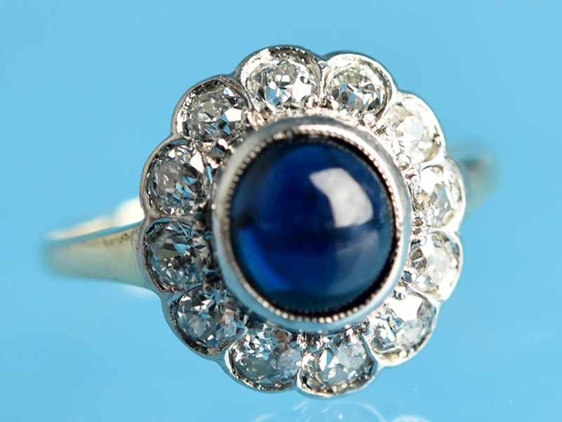 Ring mit Saphir-Cabochon und 12 Diamanten, zusammen ca. 0,24 ct, Art Deco 585/- Weiß- und