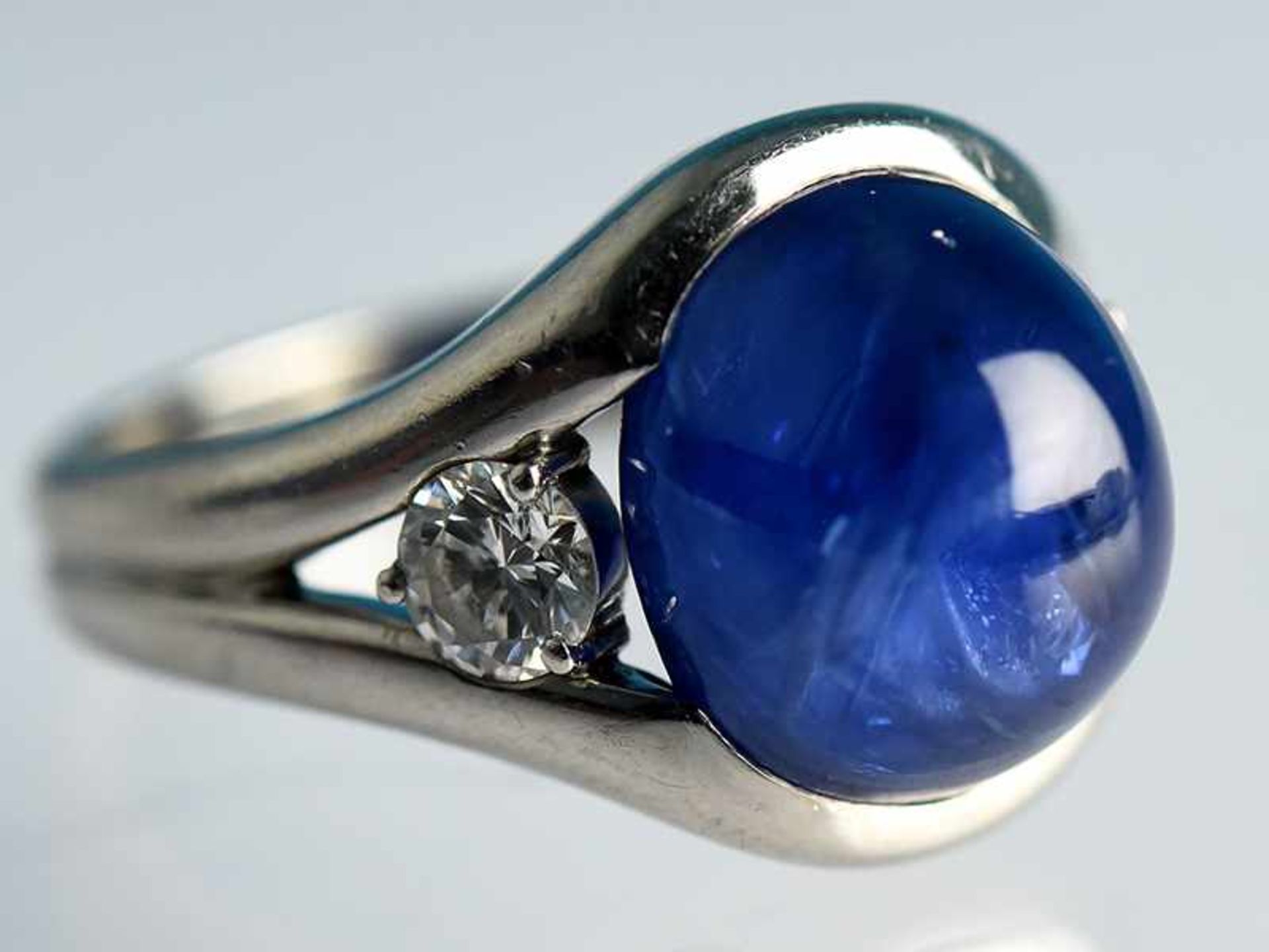 Bandring mit Saphir-Cabochon ca. 11 ct, wohl Ceylon, und zwei Brillanten, zusammen ca. 0,6 ct,