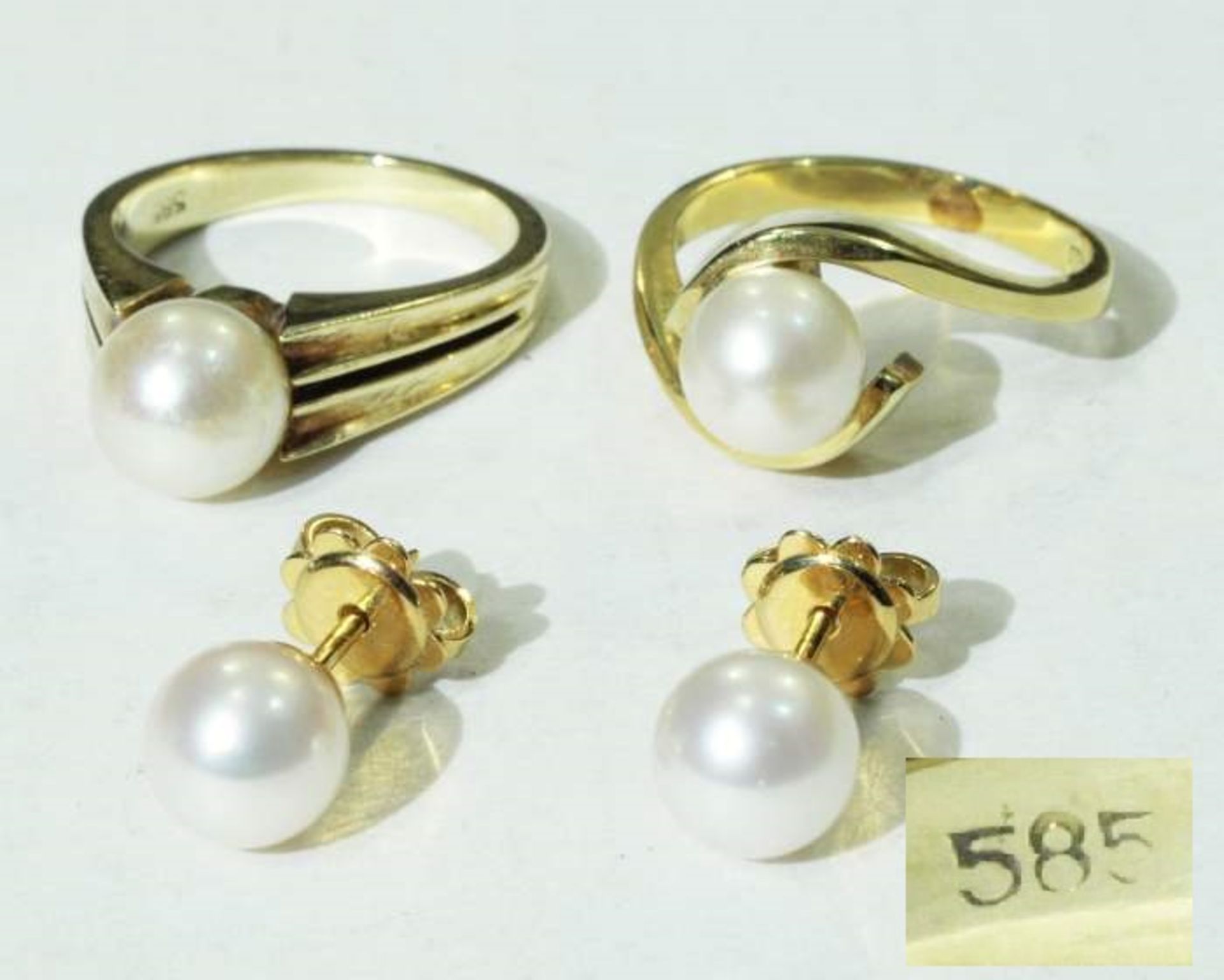 Zwei Ringe und ein Paar Ohrstecker mit weißen Akoja-Perlen. Zwei Ringe und ein Paar Ohrstecker mit