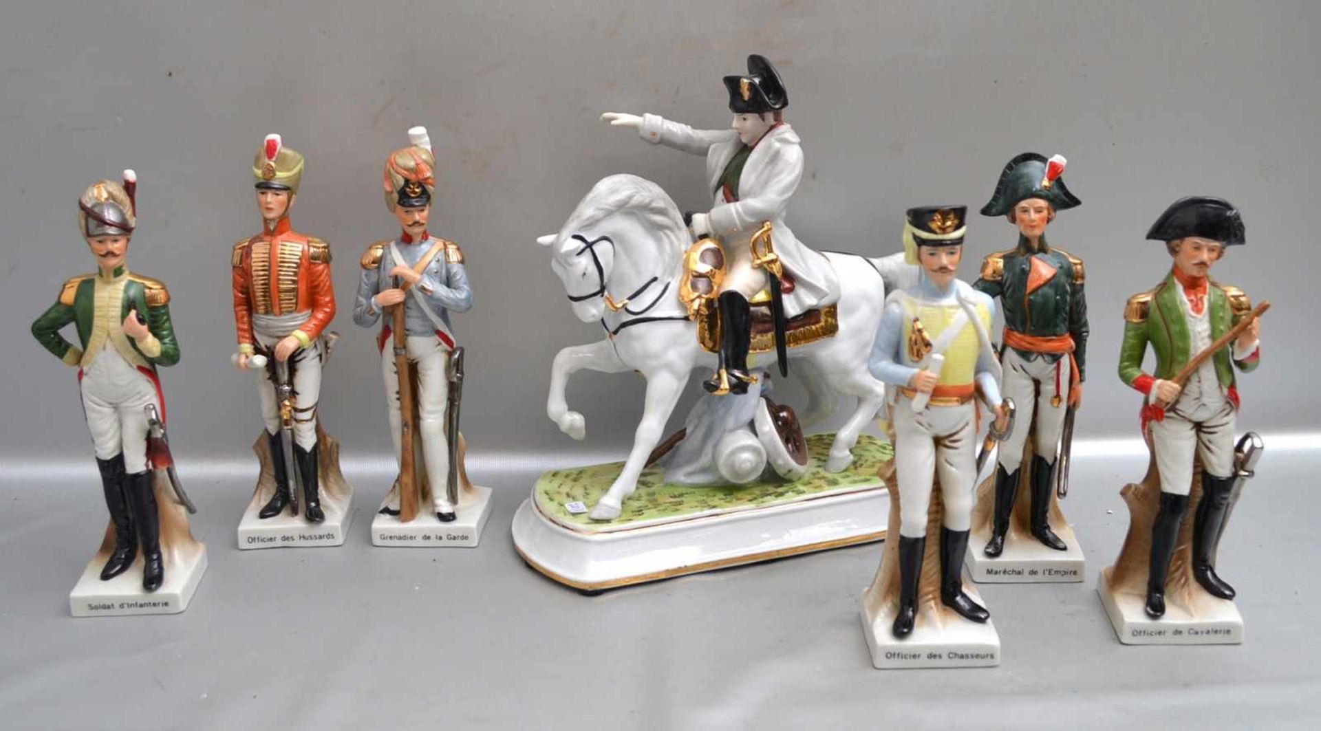 Napoleon zu Pferd und sechs Soldaten auf Sockel stehend, H 27 cm, die Soldaten tragen verschiedene