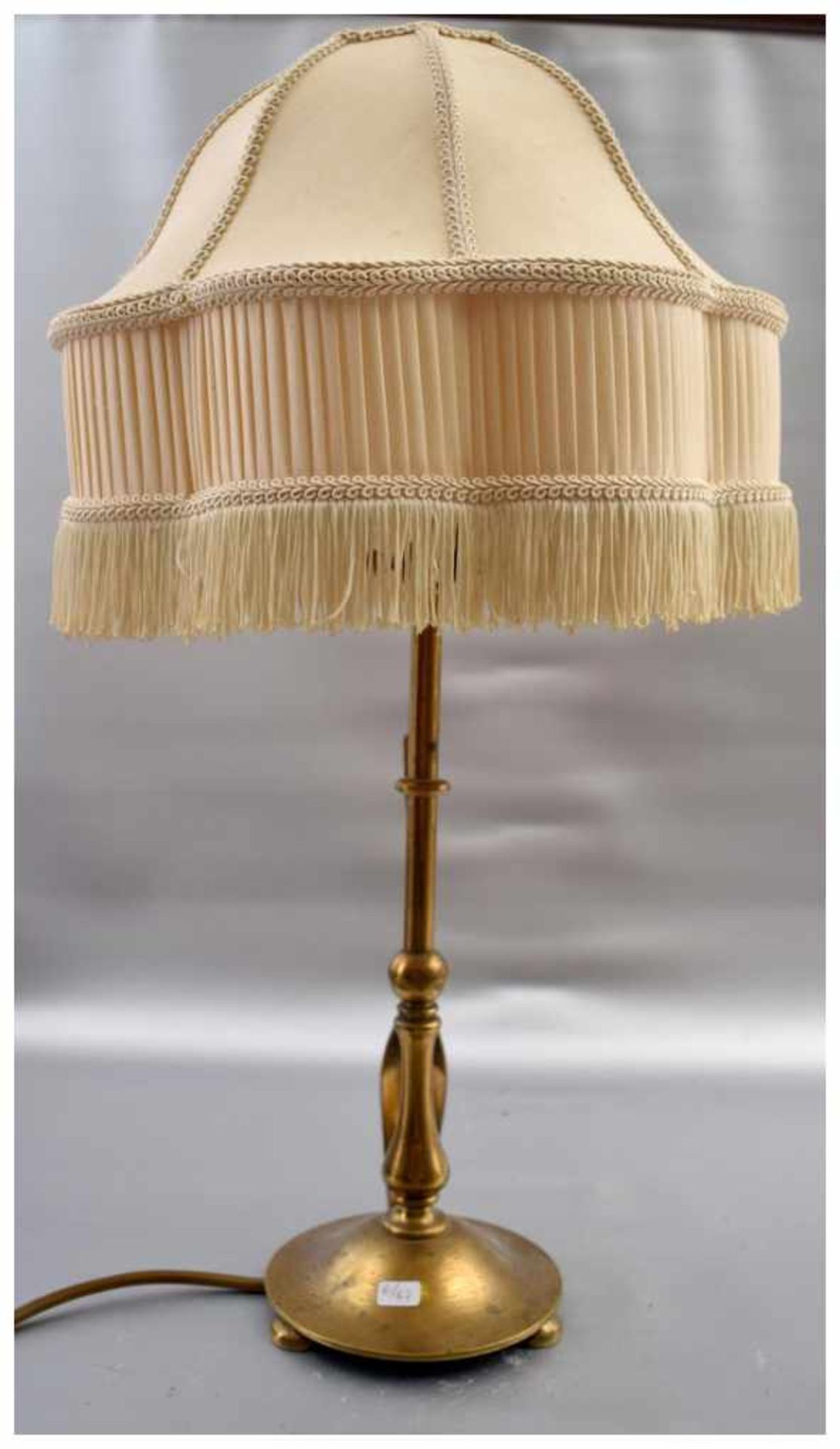 Tischlampe 1-lichtig, Messingfuß, auf drei Füßen stehend, runder gedrehter Schaft, beigefarbener