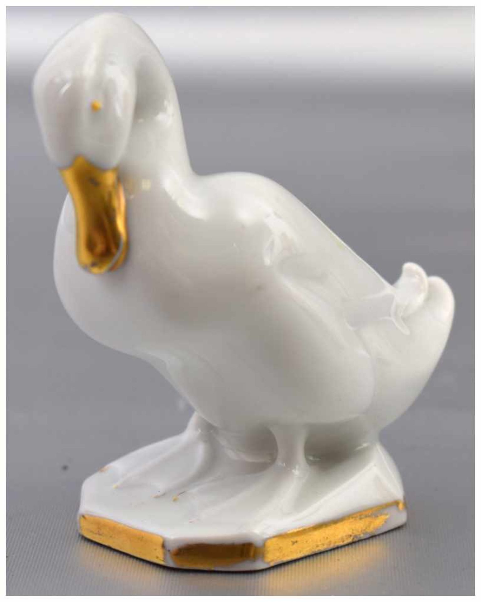 Kleine Ente auf rechteckigem Sockel stehend, gold bemalt, H 7 cm, FM Hutschenreuther