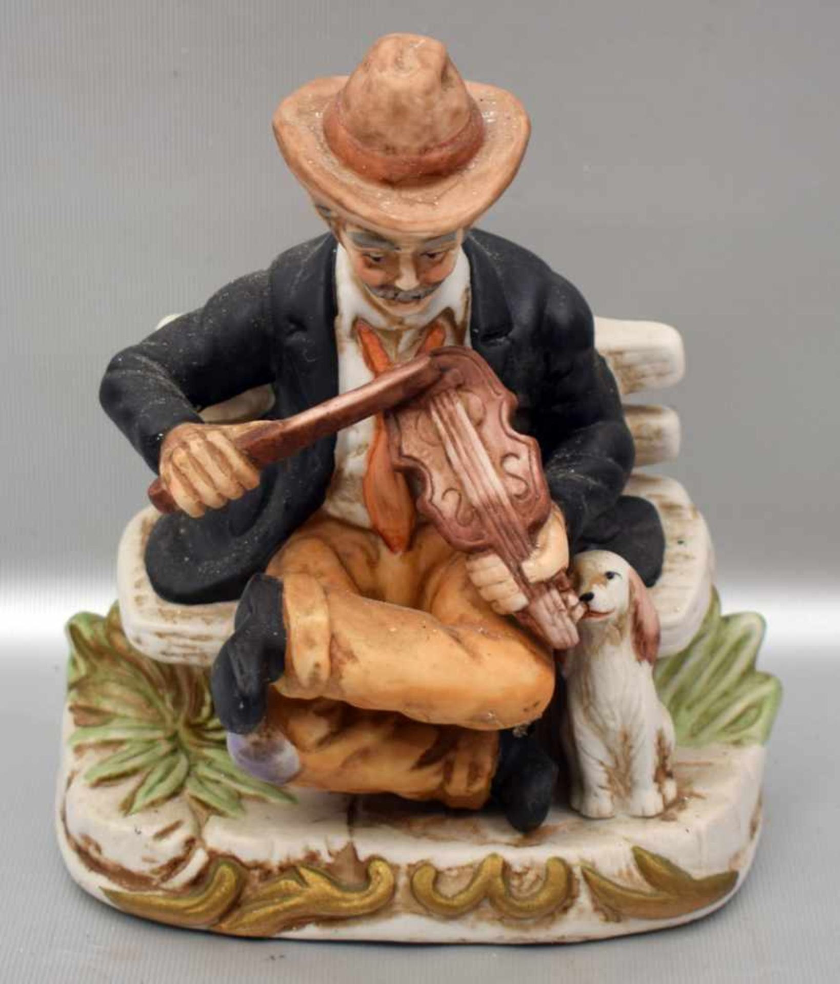 Der alte Geigenspieler Porzellan, auf rechteckigem Sockel sitzend, mit Hund, bunt bemalt, H 18 cm, B