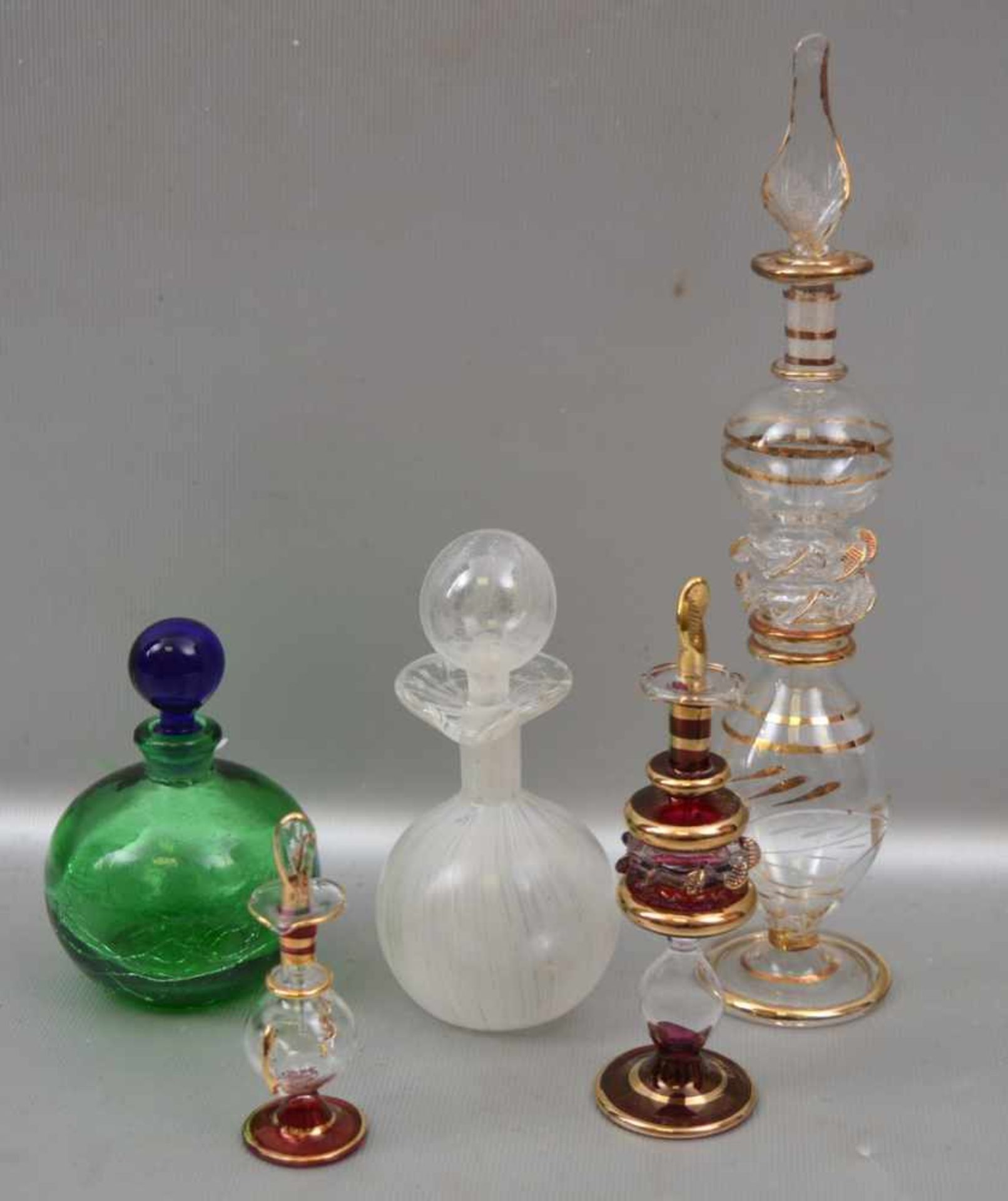 Fünf Flakons buntes Glas, verschiedene Formen und Größen, teilweise gold verziert, 70er Jahre