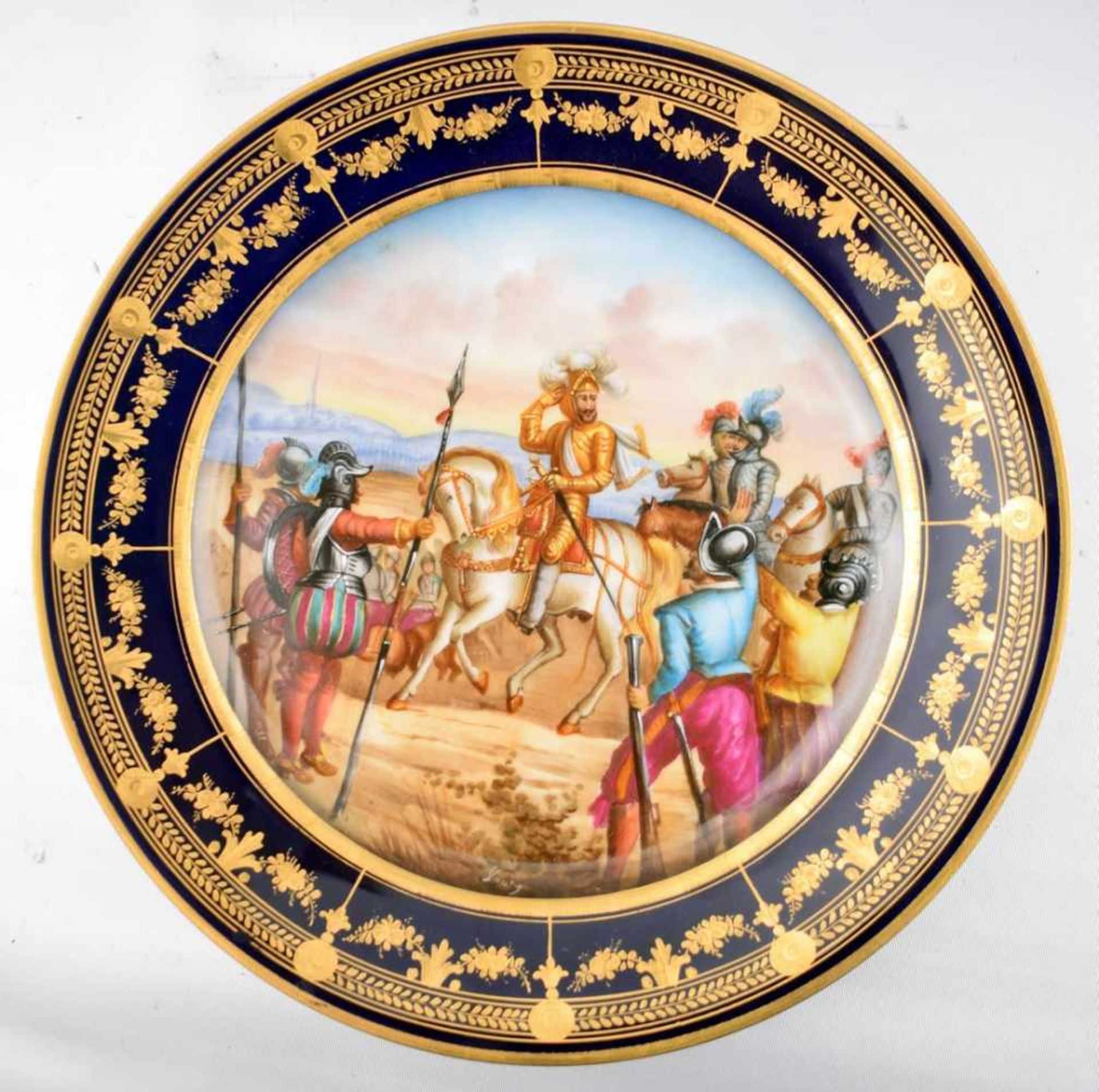 Prunk-Wandteller rund, Rand kobaltblau, gold verziert, Spiegel mit Ritter zu Pferd und Soldaten,
