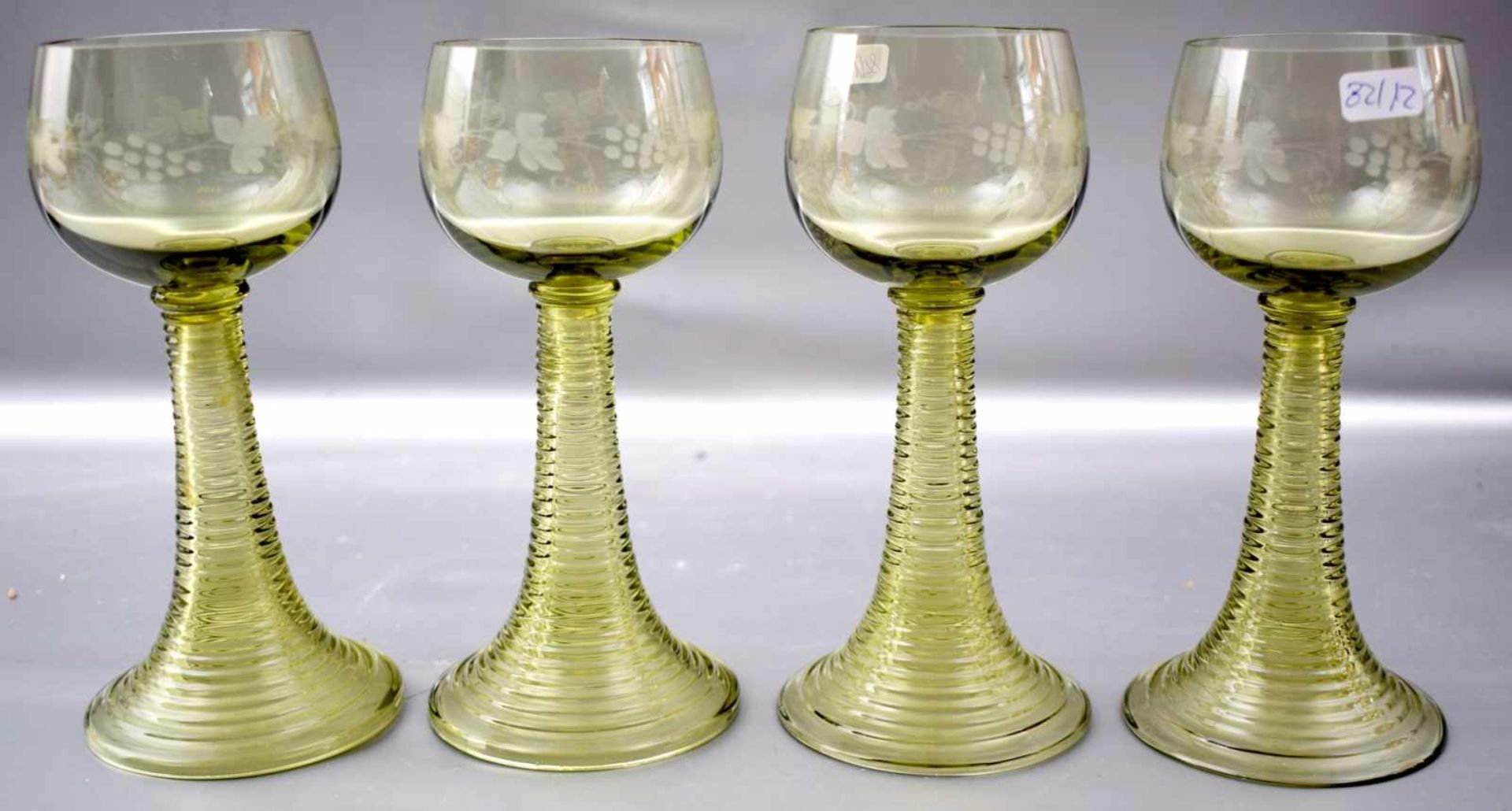 Vier Weingläser grünes Glas, runder Fuß, Kelch mit Weinranken verziert, H 17 cm, um 1900