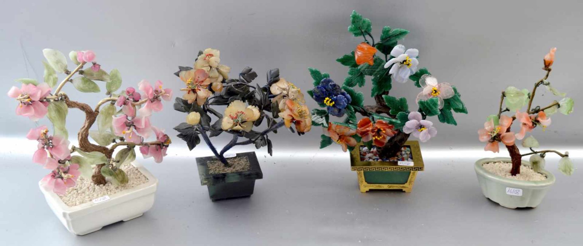 Vier Zierblumensträuße in Keramik- bzw. Metallschale, mit plastischen Blüten verziert,
