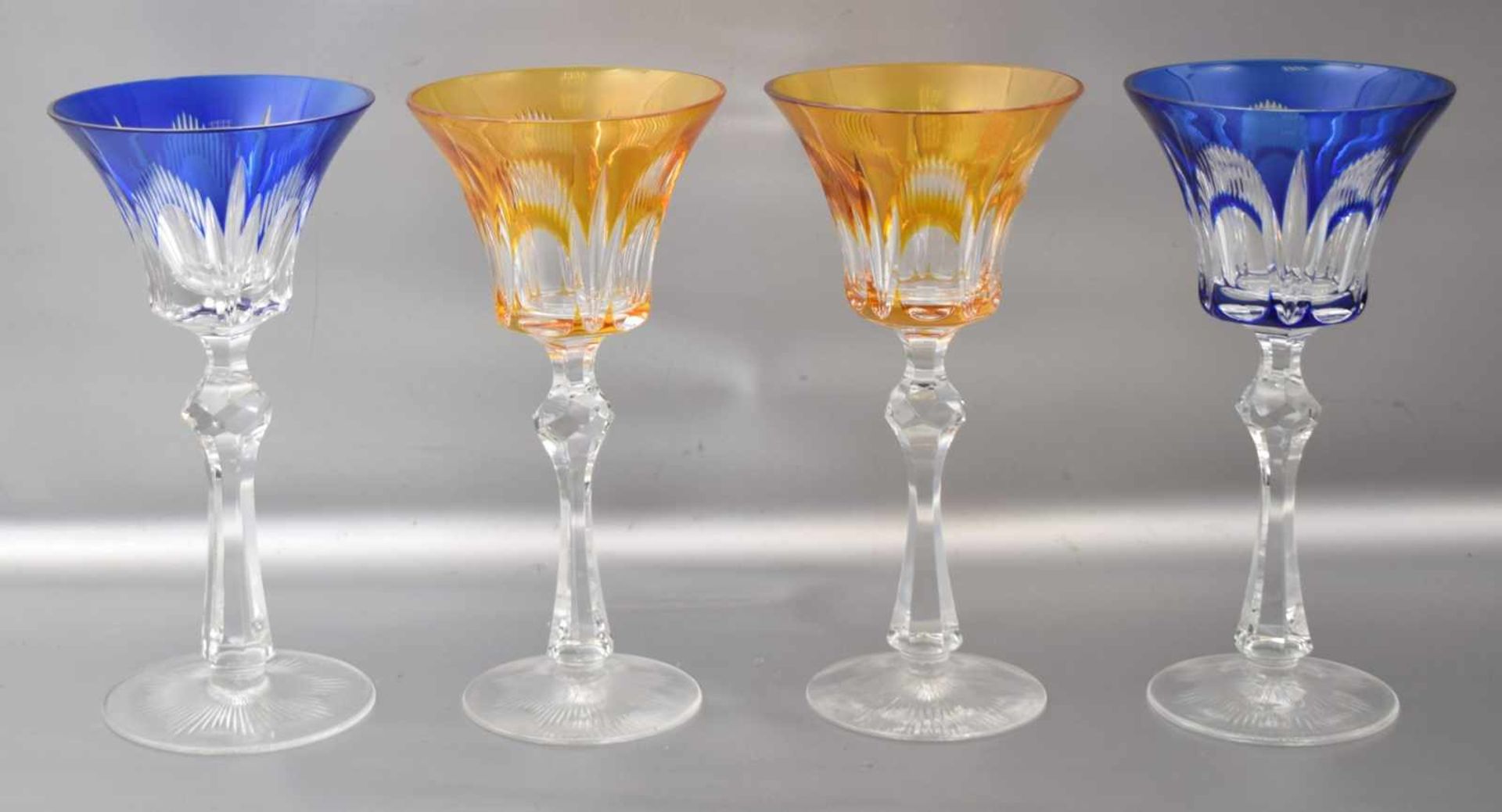 Vier Weingläser farbl. Kristallglas, geschliffen verziert, mit blauem bzw. bernsteinfarbenem