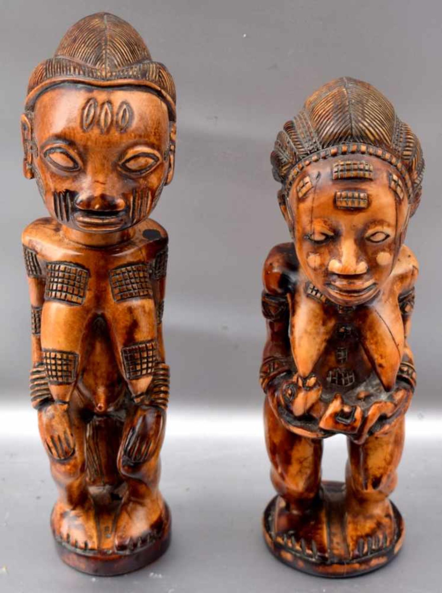 Zwei afrikanische Skulpturen Bein, geschnitzt, zwei sitzende Frauen mit Kind, H 22 bzw. 25 cm