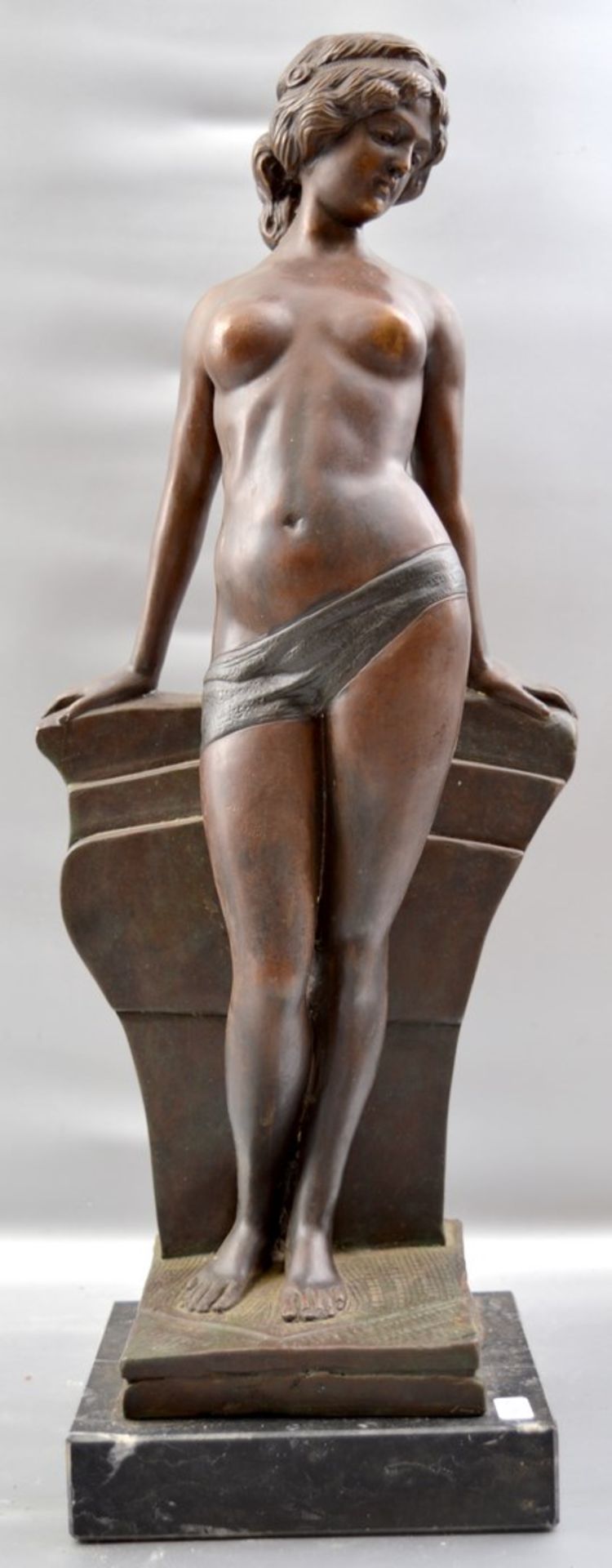 Stehender weiblicher Akt auf schwarz/grauem Marmorsockel stehend, Bronze patiniert, an Säule