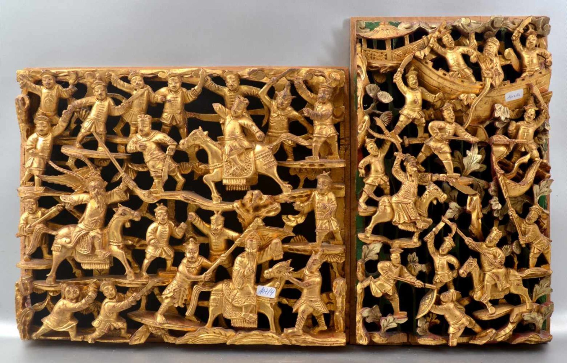 Zwei asiatische Verzierungen Hartholz geschnitzt, mit Kämpfern und Reitern, gold verziert, 32 X 27