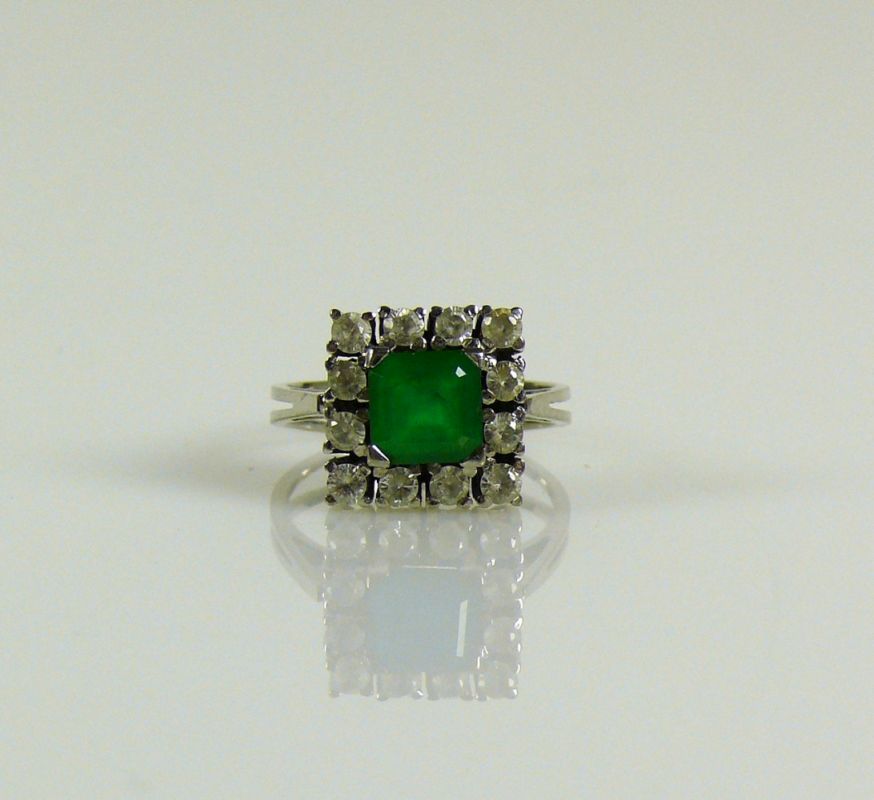 Damenring 18ct WG; mittig besetzt mit quadratischem Smaragd umgeben von 12 weißen Steinen; 7g;