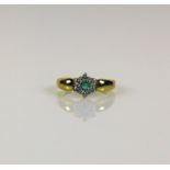 Damenring 14ct GG; besetzt mit 1 Smaragd umgeben von 6 Diamanten von zus. ca. 0,30ct; Ringgr. 60;