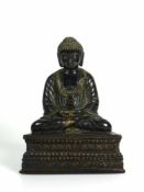 Buddha sitzend, auf Lotussockel; Bronze, dunkel patiniert; partiell vergoldet; Höhe: 20 cm