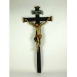 Christuskreuz (19. Jh.) vollrund geschnitzt und farbig gefasst; an geschwärztem Holzkreuz;