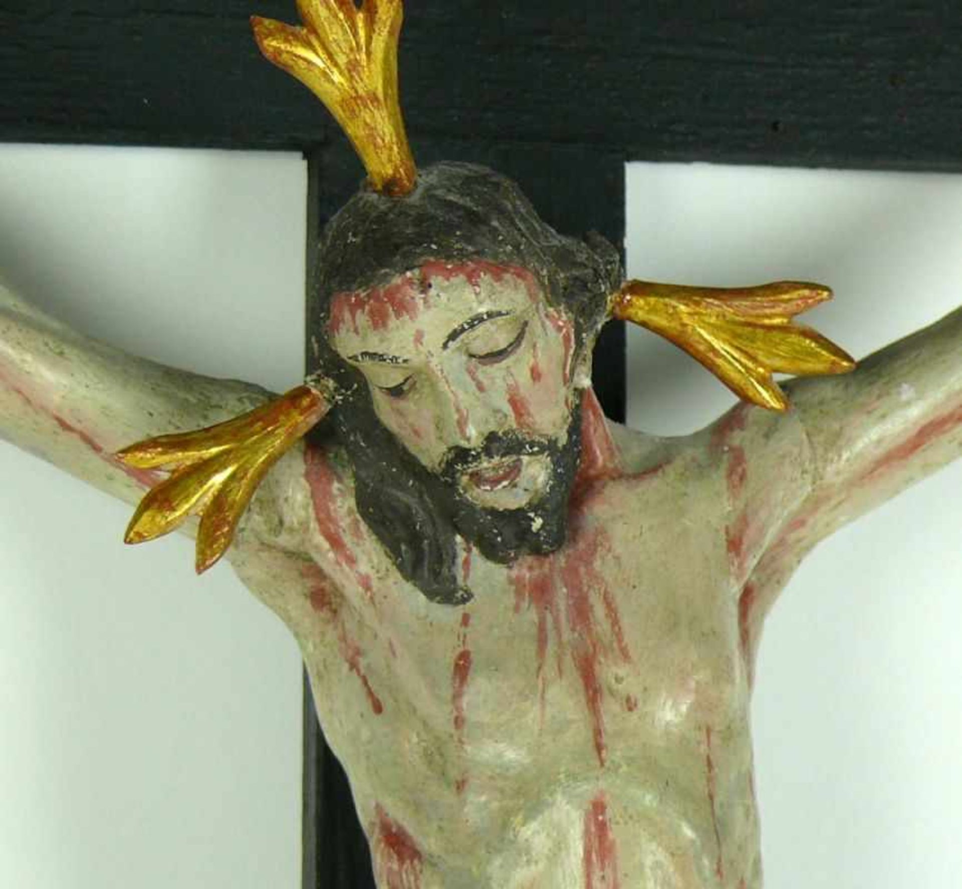 Christuskreuz (19. Jh.) vollrund geschnitzt und farbig gefasst; an geschwärztem Holzkreuz; - Bild 2 aus 2