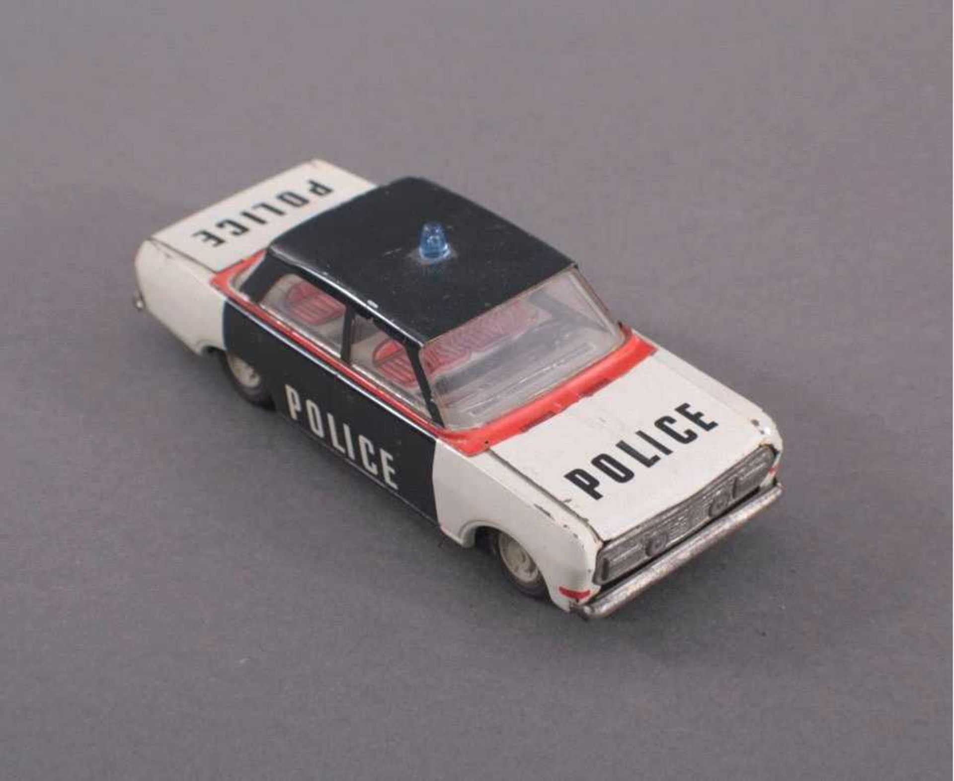 Blechspielzeug Auto, Police, DDRPolizeiauto in schwarz, weiß und rot. Blaulicht auf demDach.