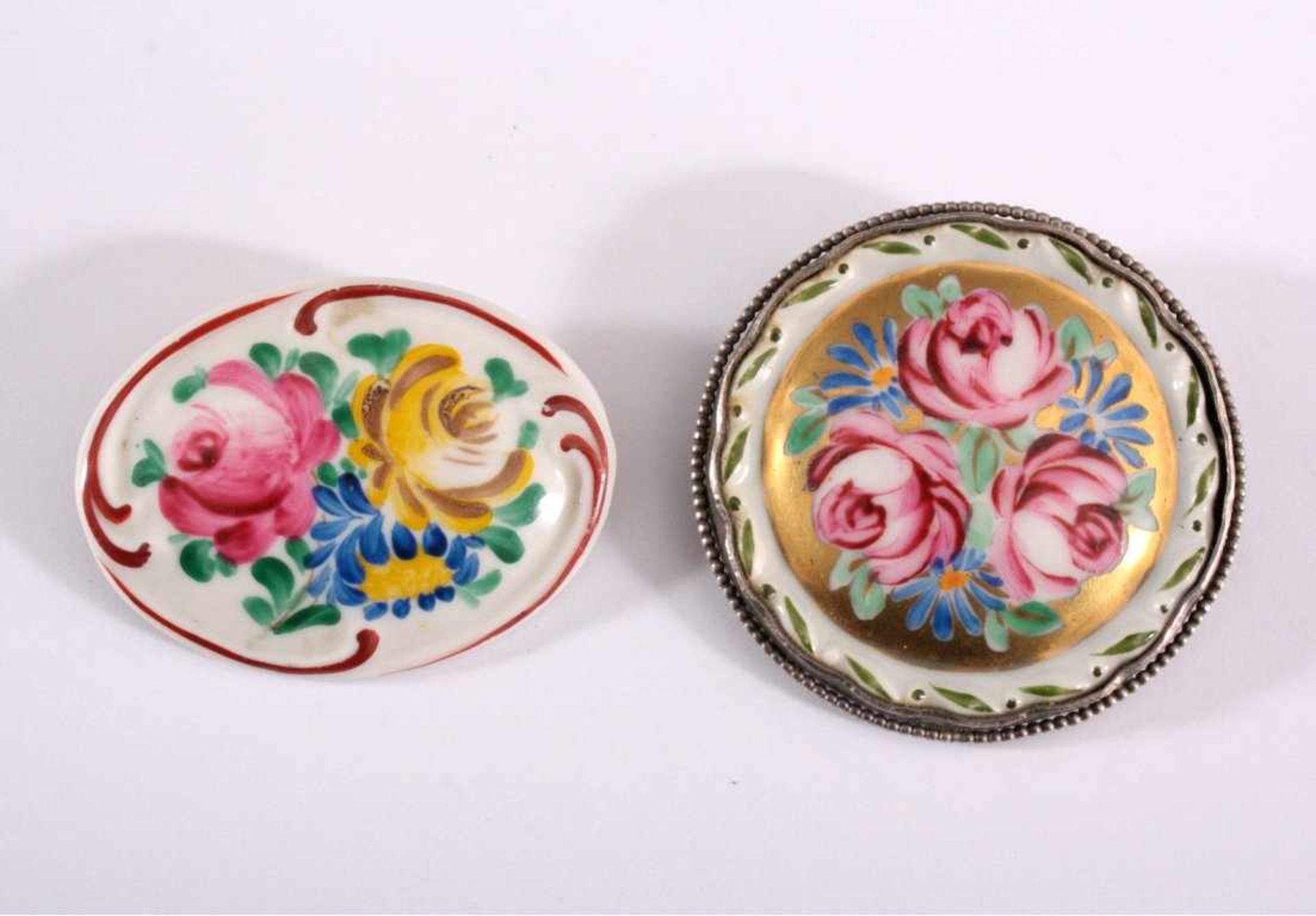 2 Porzellan-Broschen mit polychromer Blumenbemalungrunde Brosche der Manufaktur Bareuther mit