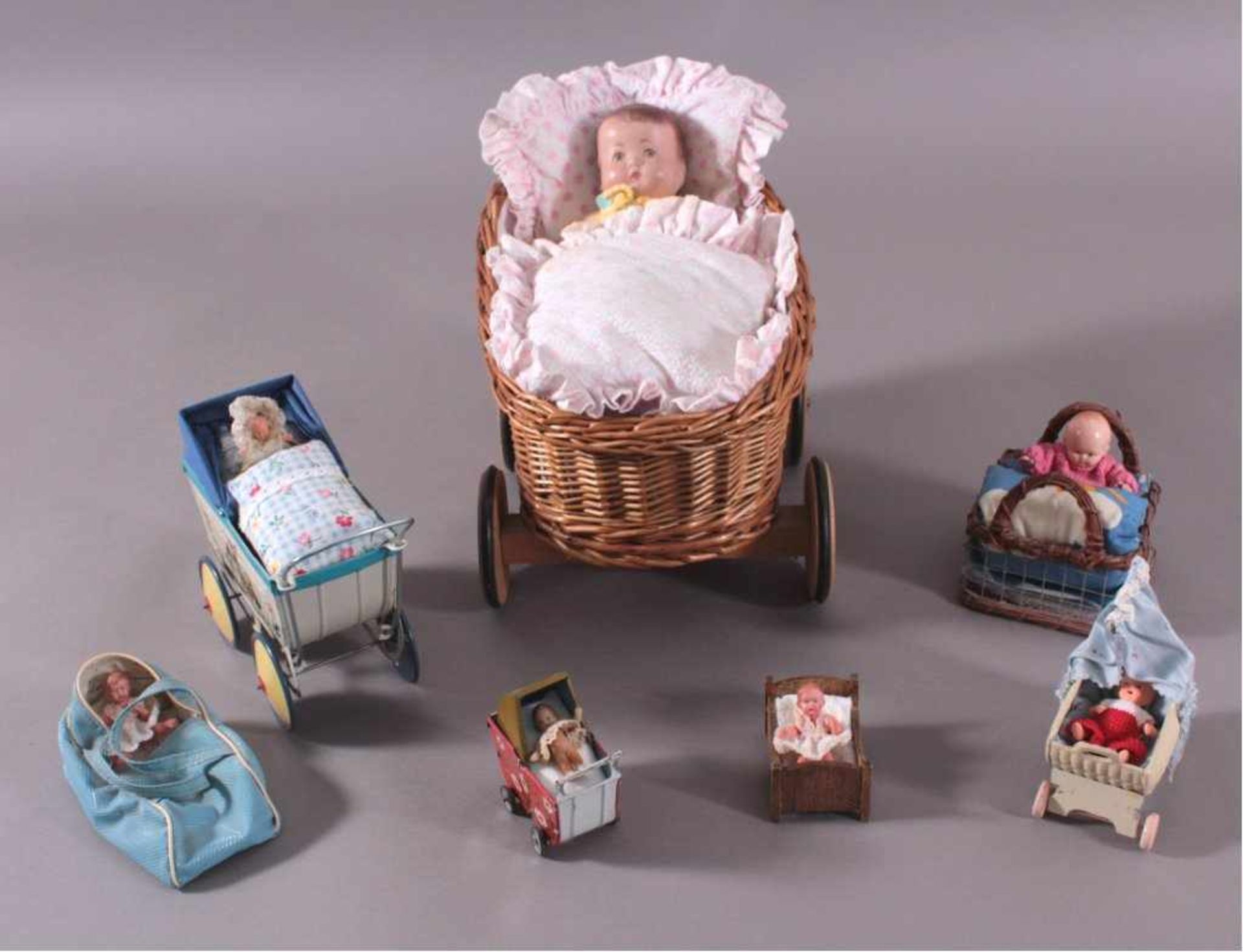 7 Puppen in PuppenwagenVerschiedene Puppenwagen / Puppenbettchen zum Teil ausBlech, ca. H- 4 cm