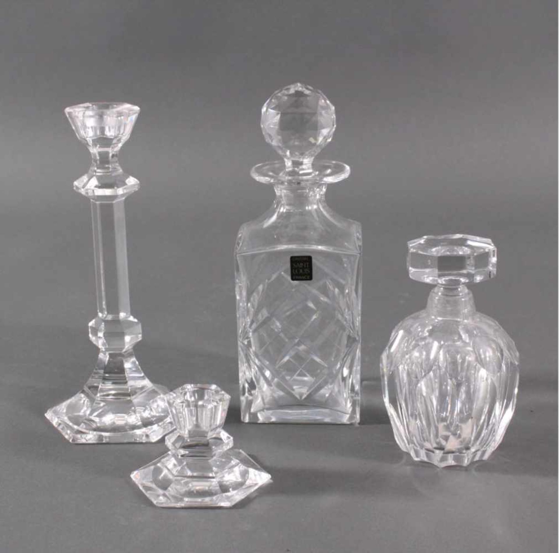 Saint Louis Kristall. 4-TeileFarbloses Kristallglas, geschliffen.2 Kerzenständer, ca. H-5,5 und 23