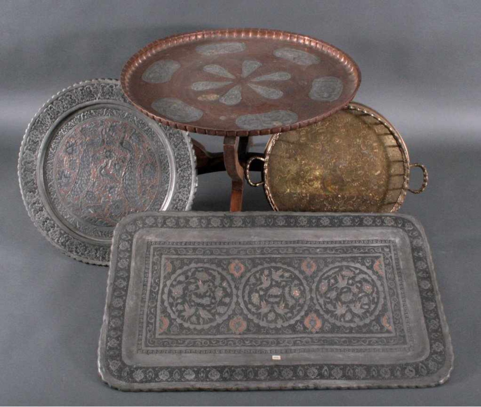Drei Tabletts und ein TischEin viereckiges Tablett aus Kupfer verzinnt, verziert mitOrnamenten,