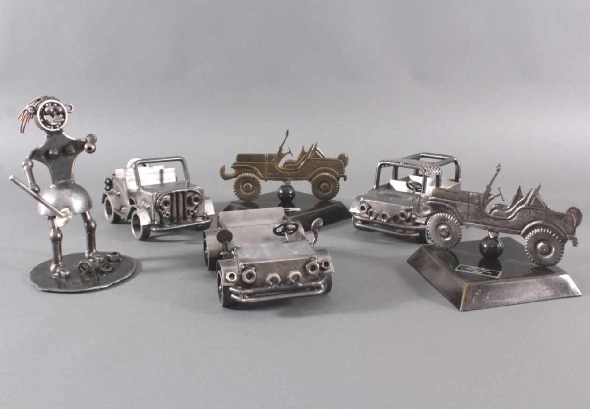 6 Skulpturen aus Eisen3 Modellautos, ca. L- 24 cm, B- 15 cm.1 Auto (Seitenperspektive auf Sockel),