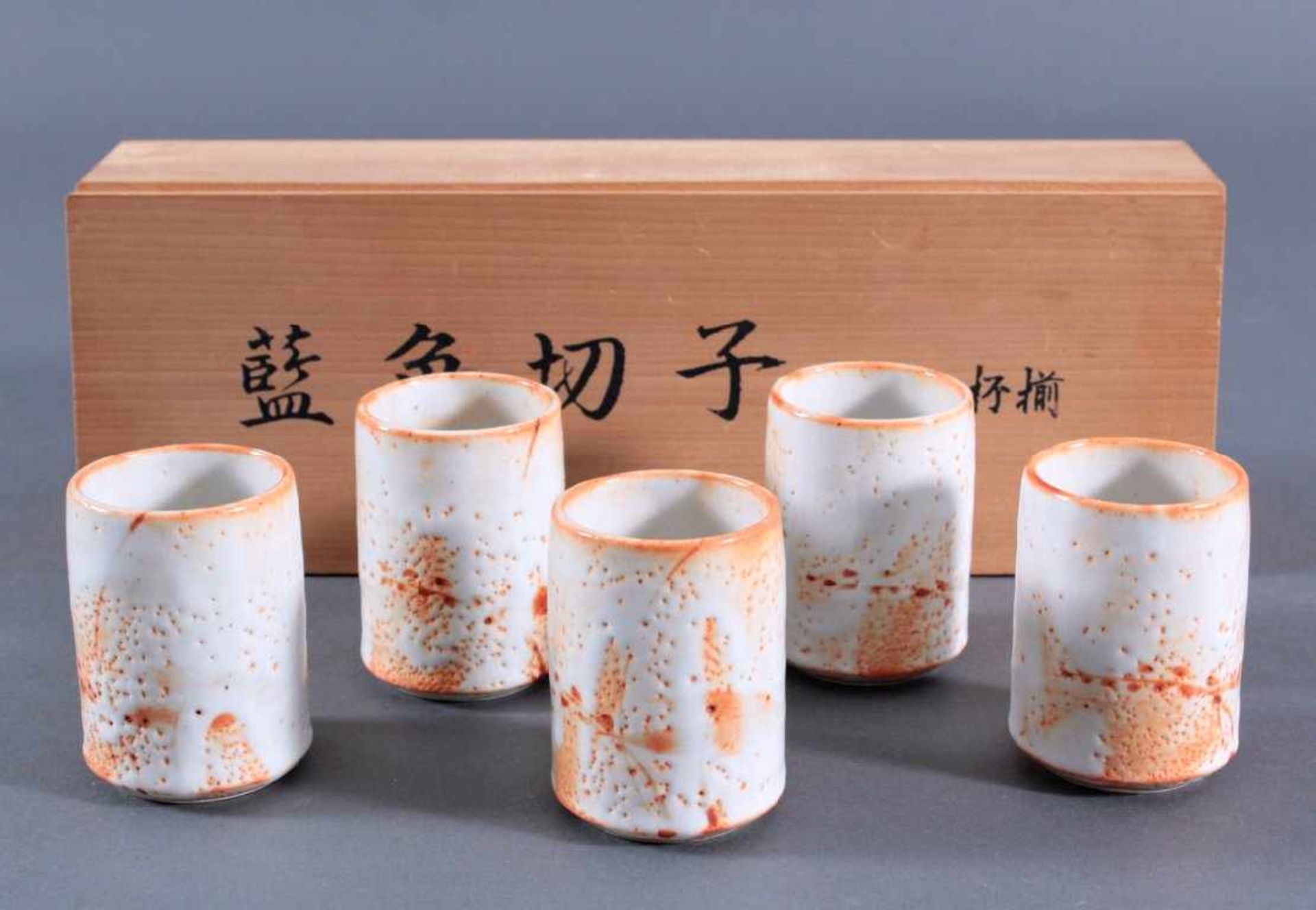 5 japanische Teetassen in Holzschatulleweiße Keramiktassen mit teilweiser orangefarbener Bemalung,