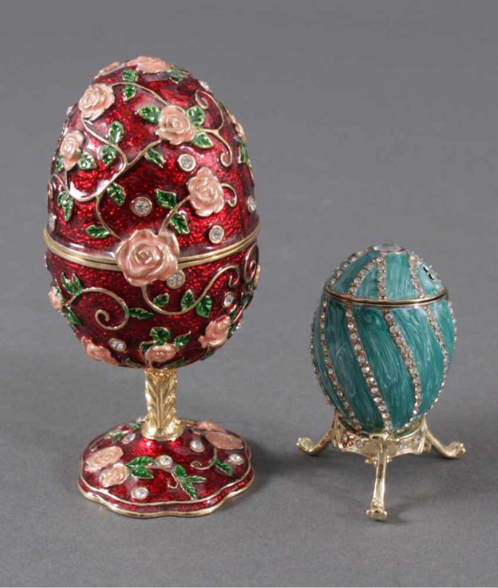 Zwei Schmuck/-Spieluhr-EierIm Fabergé-Stil. Ei und Standfuss aus Metall gegossen, dieOberfläche