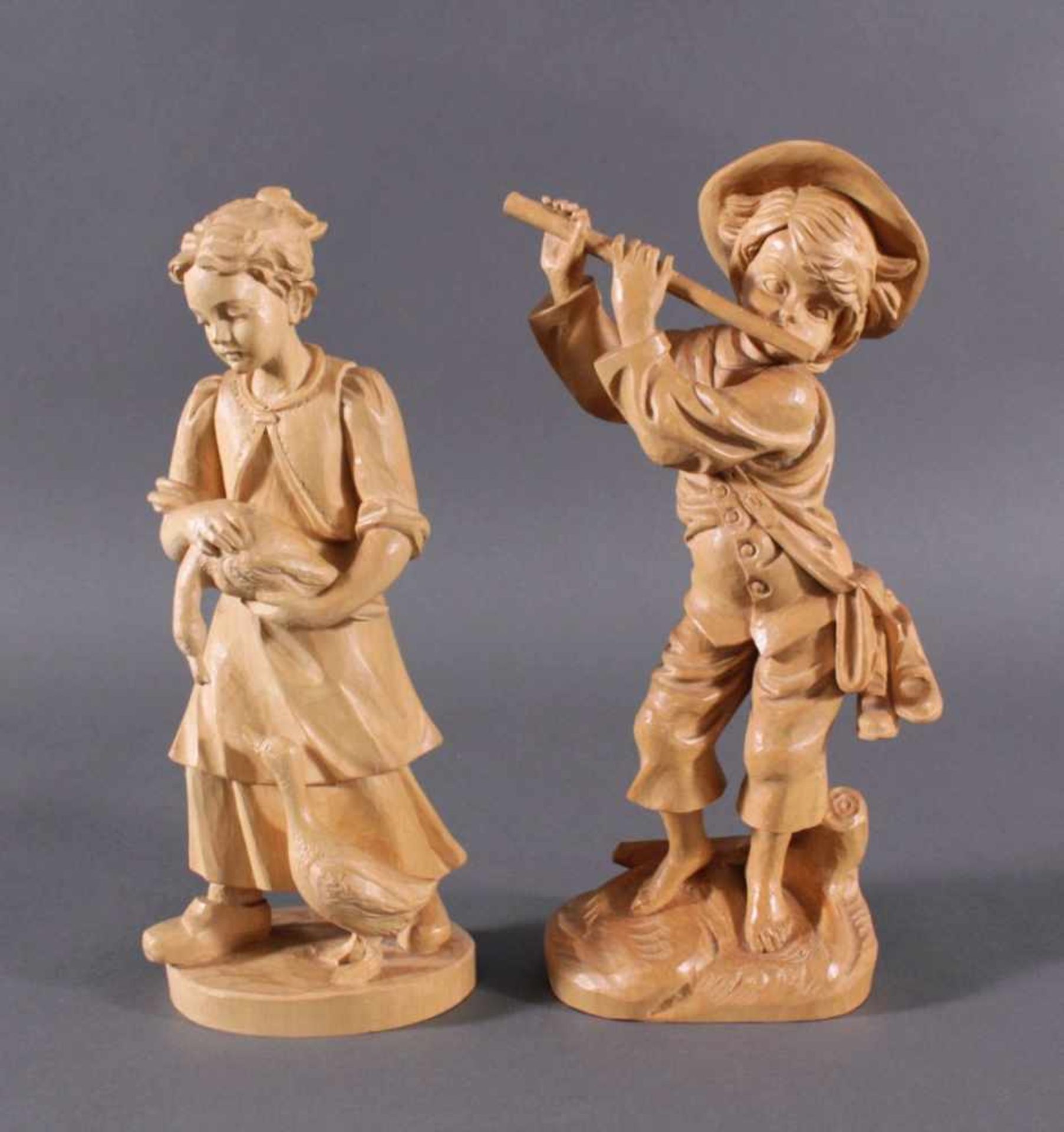 2 Holz-Skulpturen, Flötenspieler und GänselieselAus Lindenholz plastisch geschnitzt, Flöte mittig