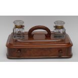 A mid 19th century rounded rectangular desk stand, with two wells, pen apertures, C-shaped handle,