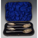A set of four Victorian silver berry spoons, typically chased and engraved, gilt bowls,