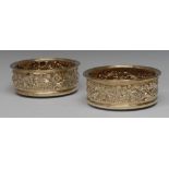 A pair of Regency style silver-gilt circular wine coasters,