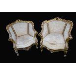 A pair of large French Louis XV style giltwood armchairs, pierced and carved leafy scroll borders,