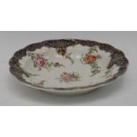 A Worcester circular scalloped shaped dish, painted with floral bouquets and leafy tendrils,